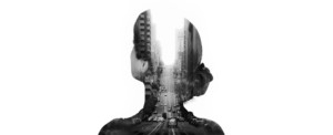 Double exposure photograph of a woman with a city blended into her silhouette.