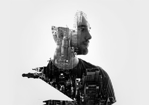 Double exposure photograph of a man with a city blended into his silhouette.